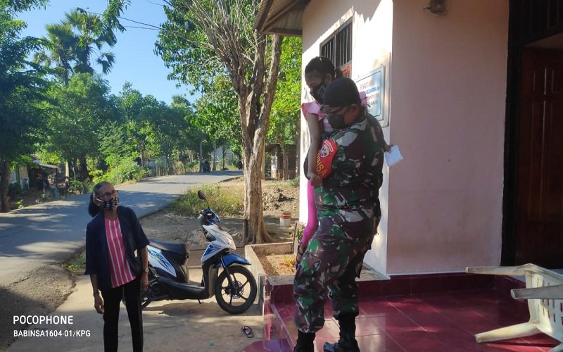 Foto Anggota Babinsa 1604-01/Kupang  ini  Gendong Warga untuk Terima Bantuan